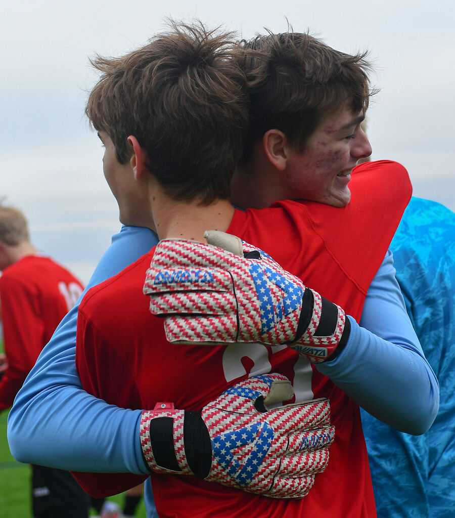Southern Boone High School goalkeeper Alex Criswell, center, hugs teammate Reece Baker after their state semi-final game